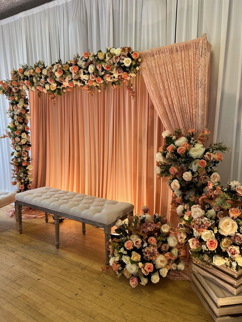 Full-height drapes with a floral arch over a bench seat