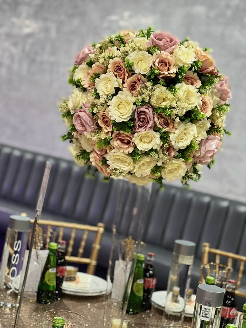 A tall floral arrangement raised on a slender stand
