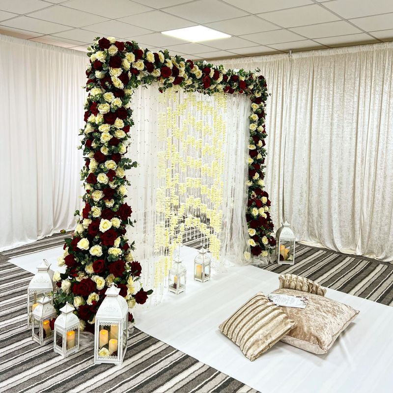 A floral arch over low seating and cushions