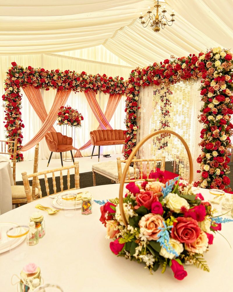 Red and pink florals on a frame above a dressed table