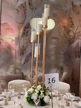 Tall gold stems carrying white florals on a dressed table