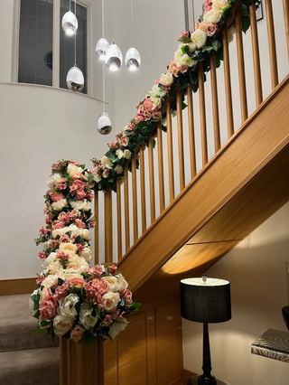 A staircase draped with pink and white florals