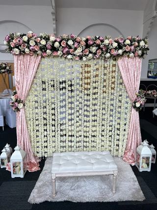 A dense floral canopy above a draped backdrop