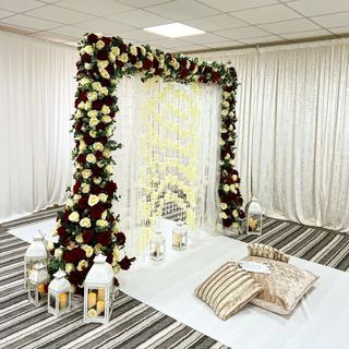 A floral arch over low seating and cushions