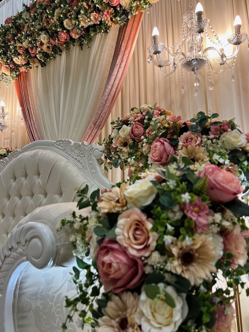 Dense pink and cream florals beneath a chandelier