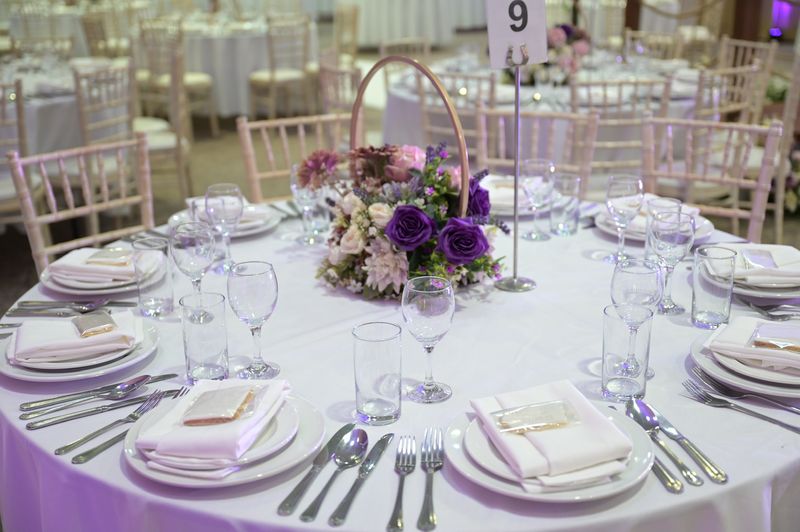A place setting with a gold candelabra and lilac florals