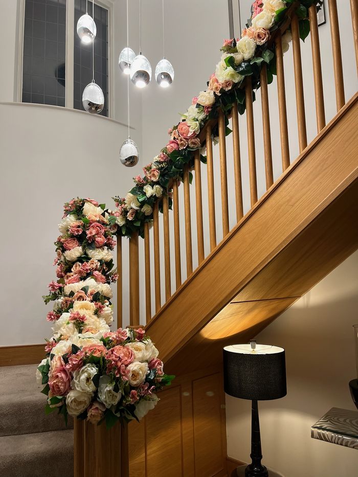 A staircase draped with pink and white florals